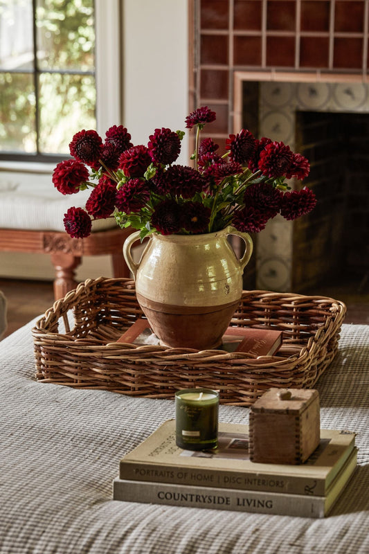 Ottoman in living room styled with tray, candles and vase