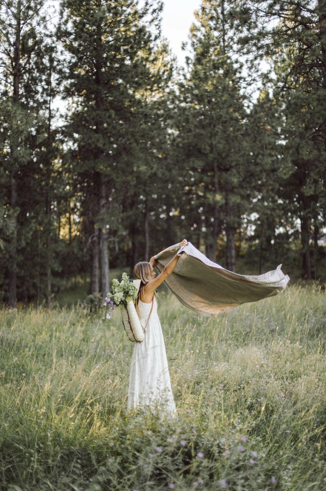 Woman in field in summer with linen fabric