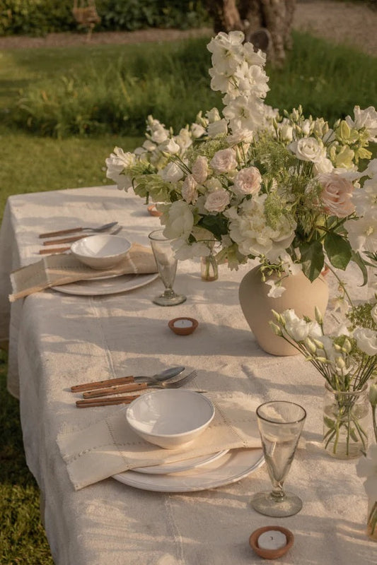 Outdoor wedding table with plates, cutlery, vases and flowers